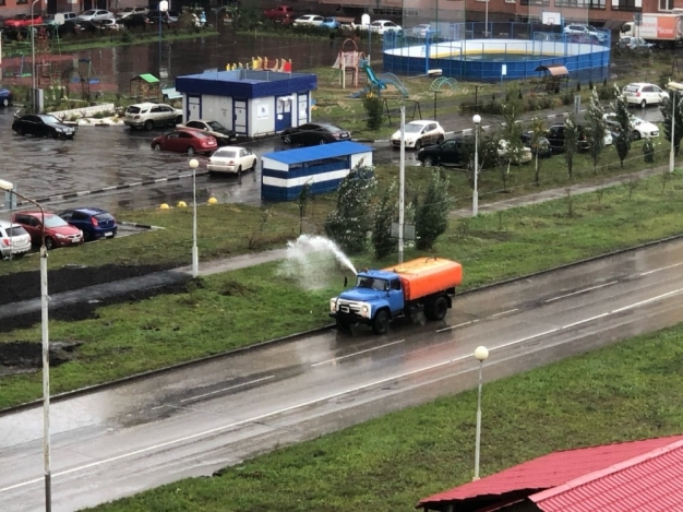 В Омске городские службы в дождь поливают траву